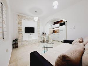 Sala de estar blanca con sofá y mesa en Paunovic Apartments, en Tivat