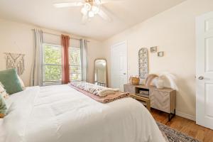 a white bedroom with a bed and a mirror at The Little Rock House in Bentonville