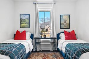 Cette chambre dispose de 2 lits avec des oreillers rouges et d'une fenêtre. dans l'établissement The Dutchman, à Bella Vista