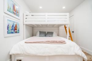 a white bedroom with a bunk bed in it at The Beehive in Lake Hamilton