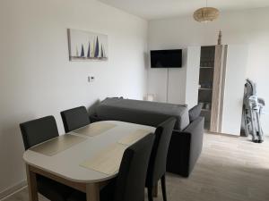 a living room with a table and a couch at Charmant T2 en centre-ville avec balcon, parking privé et équipements bébé à Fort-Mahon-Plage - FR-1-482-99 in Fort-Mahon-Plage