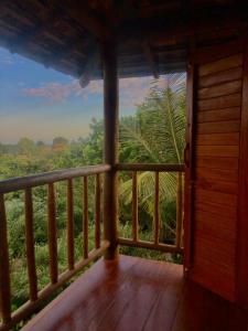 um quarto com uma varanda com vista para uma floresta em Mirante Caraiva em Caraíva