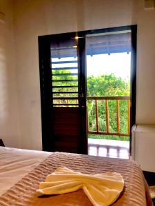 ein Schlafzimmer mit einem Bett und eine Tür mit einem Fenster in der Unterkunft Mirante Caraiva in Caraíva
