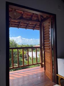 eine Tür, die auf einen Balkon mit Meerblick führt in der Unterkunft Mirante Caraiva in Caraíva