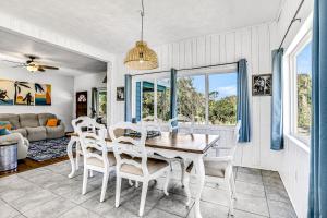 a dining room with a table and chairs and a couch at River Cottage in Edgewater