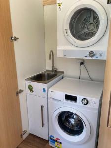 uma máquina de lavar roupa e um lavatório num quarto em Country Retreats On Ranzau 0 em Hope