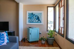 a living room with a blue cabinet and a window at Hostel Jardim das Bruxas 410 in Florianópolis