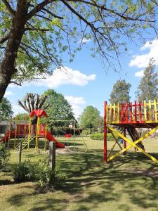un parque infantil con equipo de juego amarillo y rojo en Casa en barrio cerrado, ideal para descansar en Chascomús