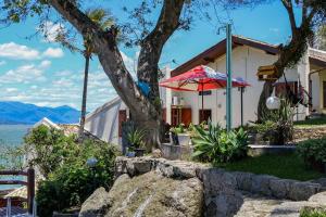 una casa con un árbol y una sombrilla en Hostel Jardim das Bruxas 410 en Florianópolis