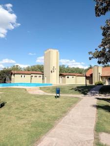 un patio con piscina y un edificio en Casa en barrio cerrado, ideal para descansar en Chascomús