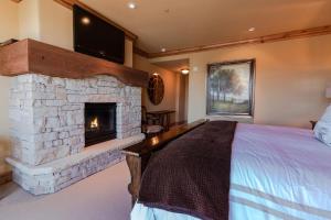 a bedroom with a fireplace and a bed and a tv at Silver Strike Condo by Lespri Property Management in Park City