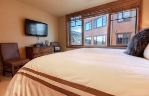 a bedroom with a large bed and a television at Silver Strike Condo by Lespri Property Management in Park City