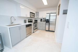 une cuisine avec des armoires blanches et des appareils en acier inoxydable dans l'établissement 2Bed 2 Bath Airbnb Friendly building with Pool, Hot Tub, and Gym, à Miami