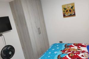 サレントにあるvivienda turistica sara & angel 2のベッドルーム(青い掛け布団、テレビ付)