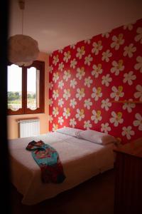 een slaapkamer met een bed met een rode muur met bloemen bij Mare Nostrum Casa Vacanza in Licata