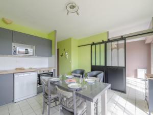 a kitchen with a table and chairs in a room at Charmant T2 Bis avec Aperçu Mer, Piscine, Parking Privé à 100m Plage - Châtelaillon-Plage - FR-1-535-29 in Châtelaillon-Plage +2 photos