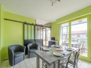 a dining room with green walls and a table and chairs at Appartement Châtelaillon-Plage, 3 pièces, 4 personnes - FR-1-535-29 in Châtelaillon-Plage
