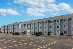 un gran edificio gris con coches estacionados en un estacionamiento en Quality Inn & Suites Grove City-Outlet Mall en Grove City