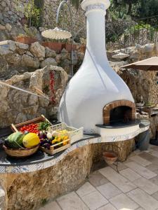 a pizza oven with a basket of fruits and vegetables at Penthouse Donna Carmela in Anacapri