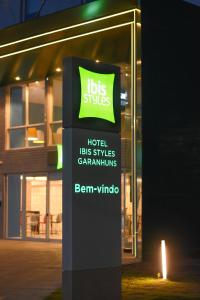 un cartello di fronte a un edificio con un cartello illuminato di Ibis Styles Garanhuns a Garanhuns