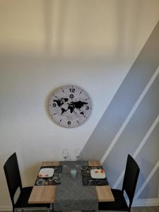 una mesa con sillas y un reloj en la pared en Komfortable Fewo nähe Südstrand, en Wilhelmshaven