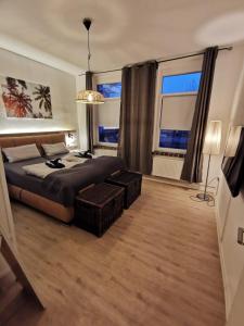 1 dormitorio con 1 cama y 2 ventanas grandes en Komfortable Fewo nähe Südstrand, en Wilhelmshaven