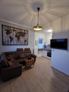 sala de estar con sofá y TV y cocina en Komfortable Fewo nähe Südstrand, en Wilhelmshaven