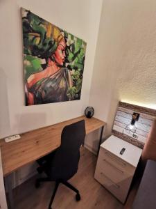 una oficina con un escritorio con una pintura en la pared en Komfortable Fewo nähe Südstrand, en Wilhelmshaven