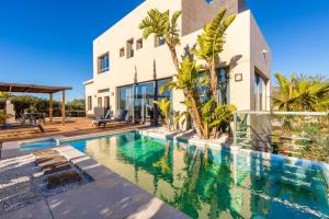 a villa with a swimming pool in front of a house at Luxury Villa with swimming pool and amazing views in Málaga