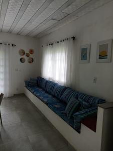 a long couch in a room with a window at Recanto das Palmeiras Praia da Longa in Angra dos Reis