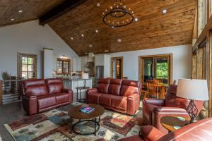 a living room with leather furniture and a table at Clouds Rest at Eagles Nest in Beech Mountain