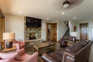 a living room with leather furniture and a fireplace at Clouds Rest at Eagles Nest in Beech Mountain