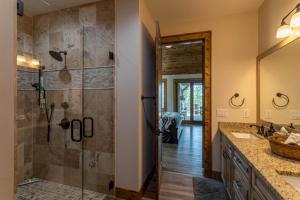 a bathroom with a shower and a sink and a mirror at Clouds Rest at Eagles Nest in Beech Mountain