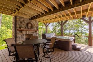 a deck with a hot tub and a table and chairs at Clouds Rest at Eagles Nest in Beech Mountain