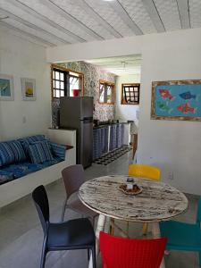a kitchen and living room with a table and chairs at Recanto das Palmeiras Praia da Longa in Angra dos Reis