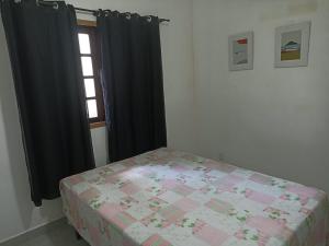 a bedroom with a bed and a window at Recanto das Palmeiras Praia da Longa in Angra dos Reis
