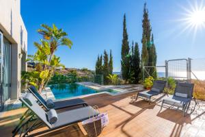 un patio con piscina y 2 sillas en Luxury Villa with swimming pool and amazing views, en Málaga
