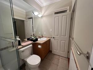 a bathroom with a toilet and a sink and a mirror at Lucky room, A comfortable suite close to YVR Richmond in Richmond