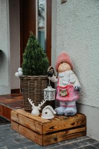 una muñeca sentada en una caja de madera junto a una planta en Anca's Haus, en Schwanstetten