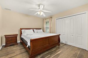 1 dormitorio con 1 cama y ventilador de techo en Modern Vacation Home w/ Heated Pool 10min to the Beach en Palm Coast
