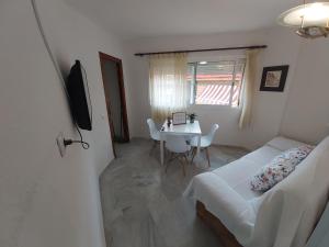 a bedroom with a bed and a table and a table and chairs at Apartamento Sostoa 4 in Málaga