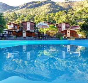 a view of the water in front of houses at Pousada Aracê in Pedra Azul