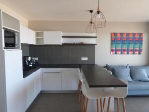 a kitchen and living room with a table and a couch at Appartement 2 chambres, balcon, accès plage, piscine, parking, animaux admis - La Tranche-sur-Mer - FR-1-194-232 in La Tranche-sur-Mer