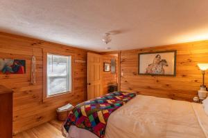 1 dormitorio con paredes de madera y 1 cama en una habitación en Hidden Cabin on Old Field Creek, en Fleetwood