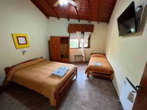 a bedroom with two beds and a flat screen tv at Hotel Los Ángeles in San Clemente del Tuyú