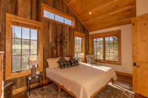 a bedroom with a bed in a room with wooden walls at Banner Sky in Banner Elk