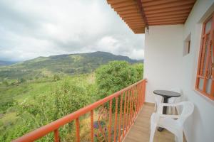 a balcony with a chair and a view of a mountain at Cabaña Mirador Angelita in Nuevo Colón