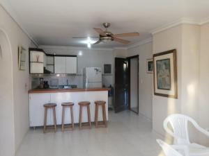 cocina con taburetes y ventilador de techo en Apartaestudio con piscina y parqueadero, en Santa Marta
