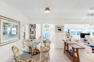 a dining room and living room with a glass table and chairs at Casa Del Mar in Key Colony Beach