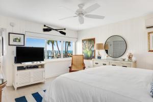 a bedroom with a bed and a flat screen tv at Casa Del Mar in Key Colony Beach